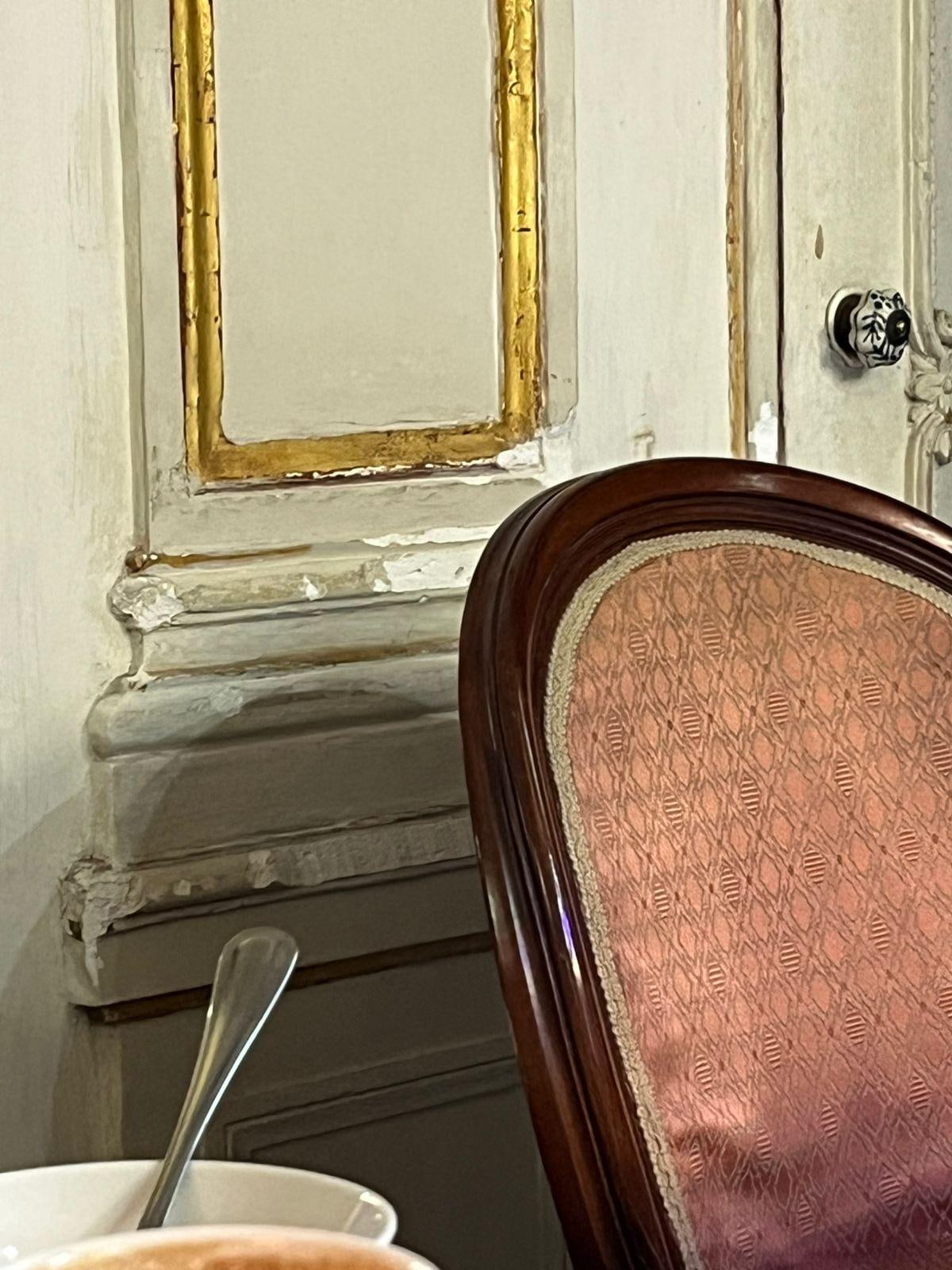 Sala de café com parede e cadeira mal conservada