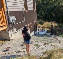 Looking down the side of of house to the rental suite. My daughter and 6' Grandson note the slope on the foundation. the picture in the listing did not show that slope