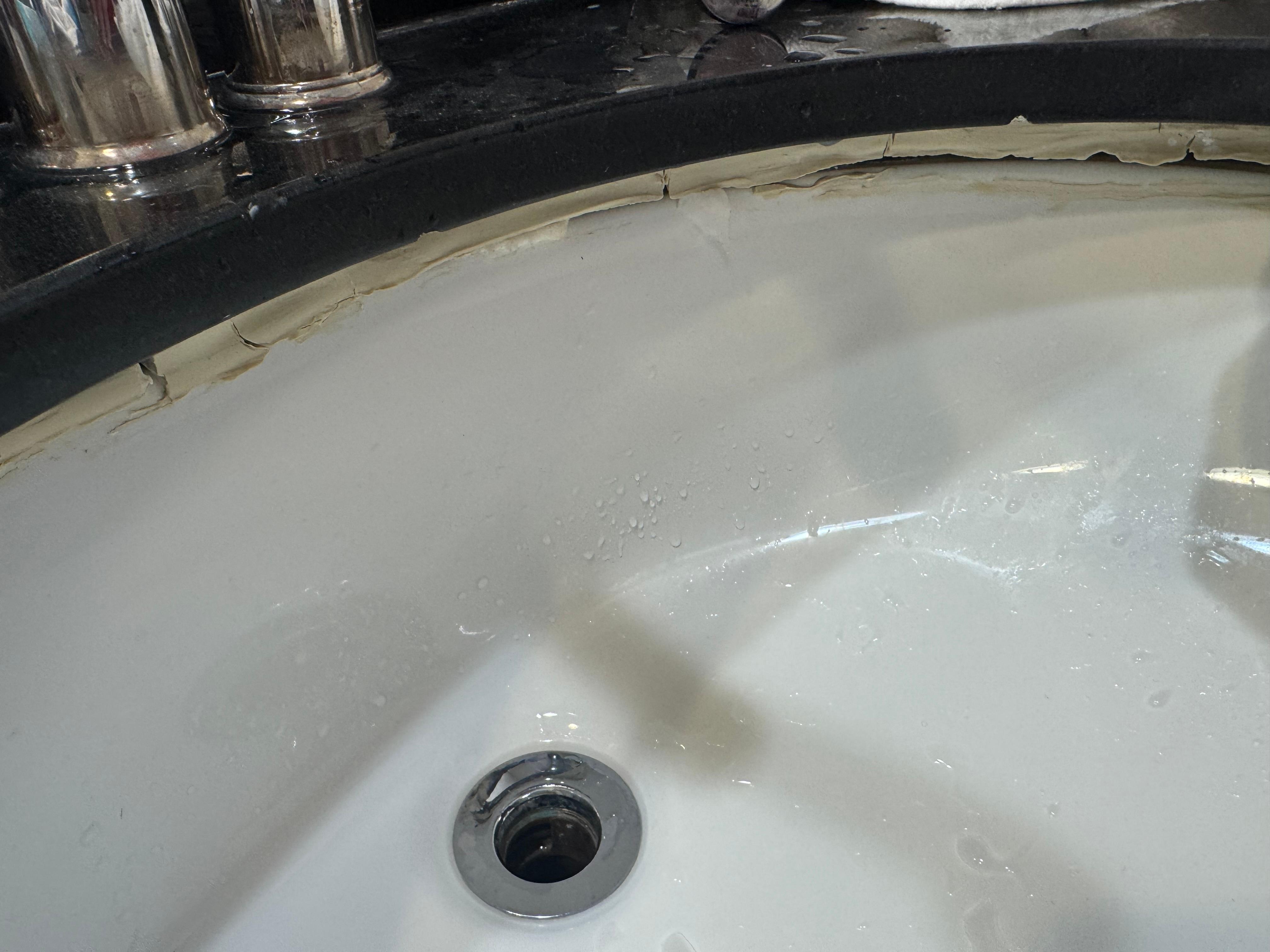 Sink with moldy and falling caulking. Drain also didn’t work (hence why the plug is pulled out) 