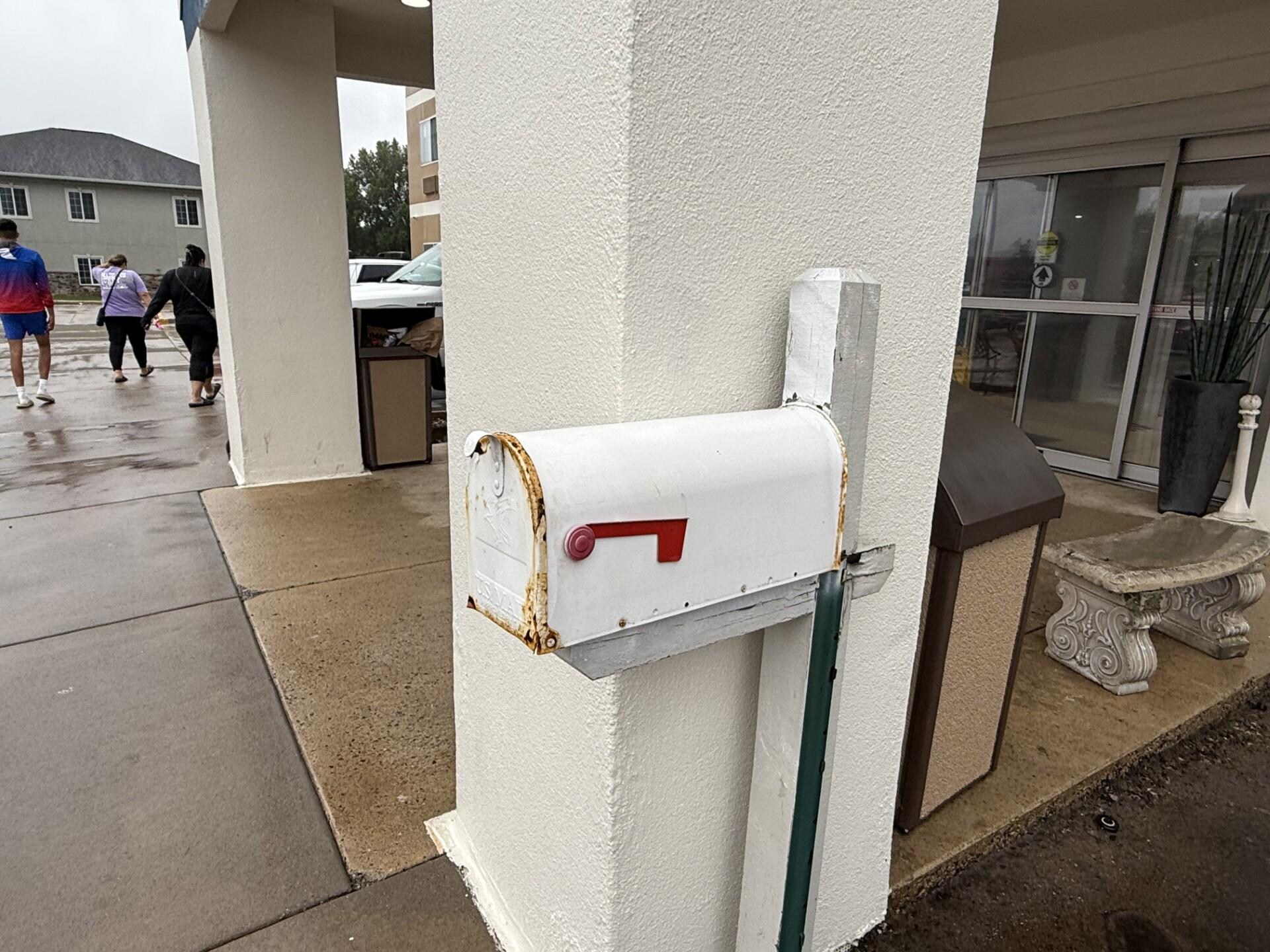 This unattractive mailbox with rust is right by the front entrance. 