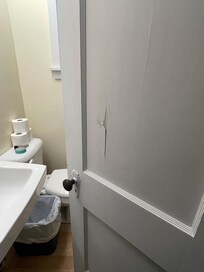 Bathroom door does not shut and looks like it lost a fight