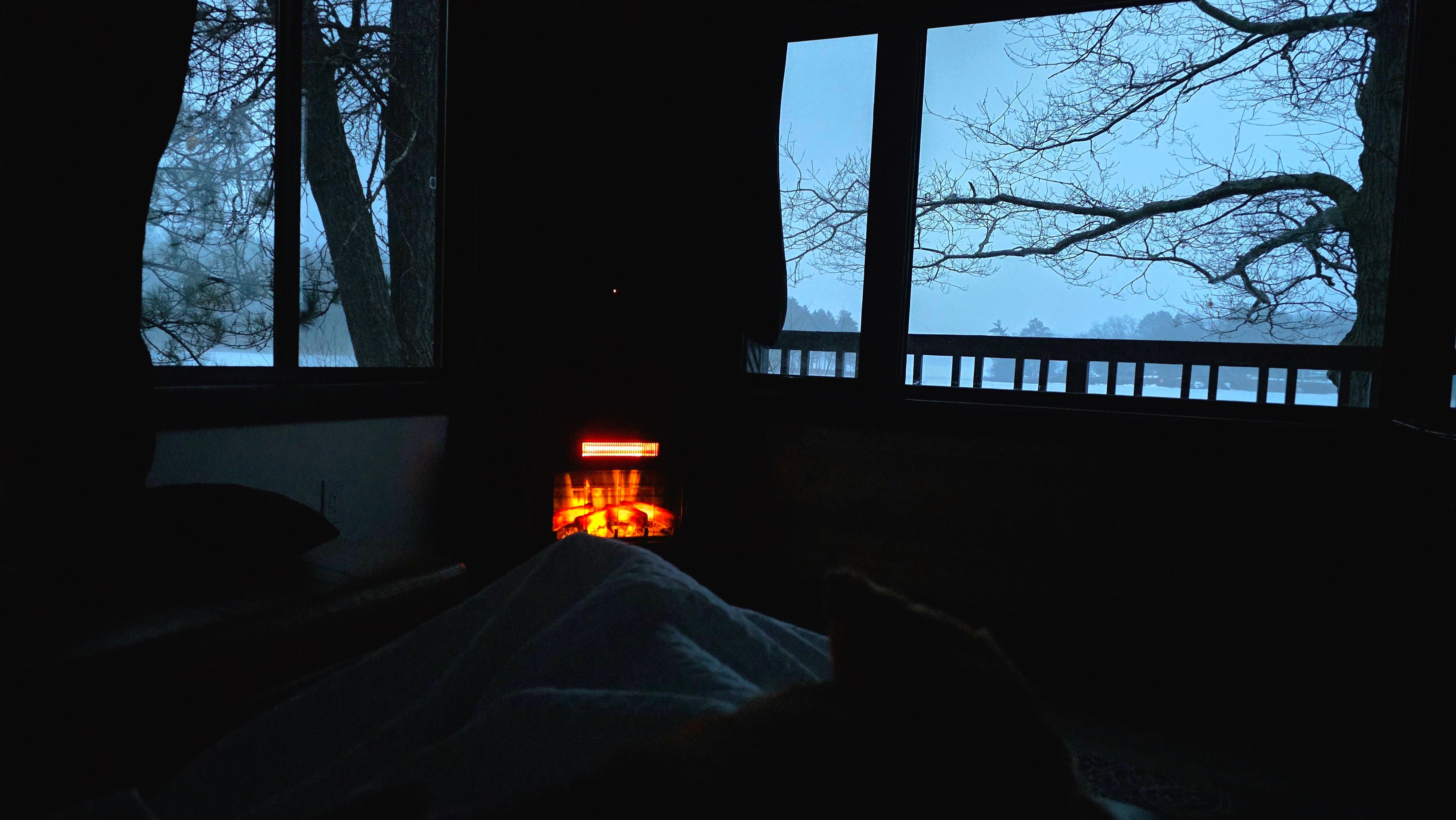 Coze fireplace in the living room with lots of windows
