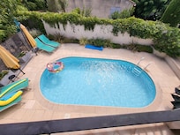 Het zwembad vanop het balkon, met ligmatras en zwembad aanwezig.