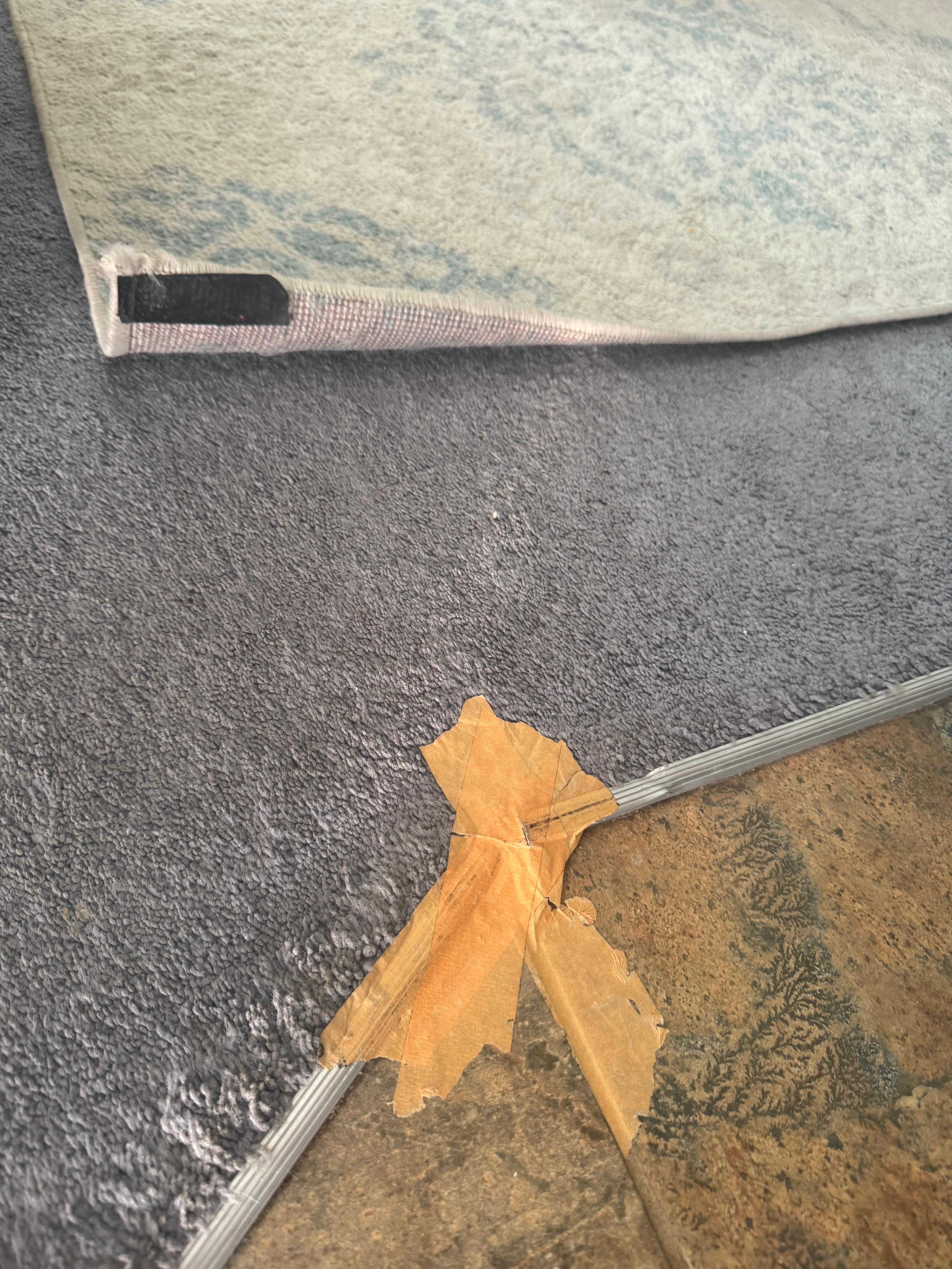 Torn rug and duck tape used to tack it down 