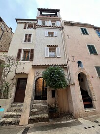 Facade with entrance and balcony at top.