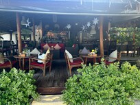 Restaurangen med utsikt över havet och stranden med solnedgång.