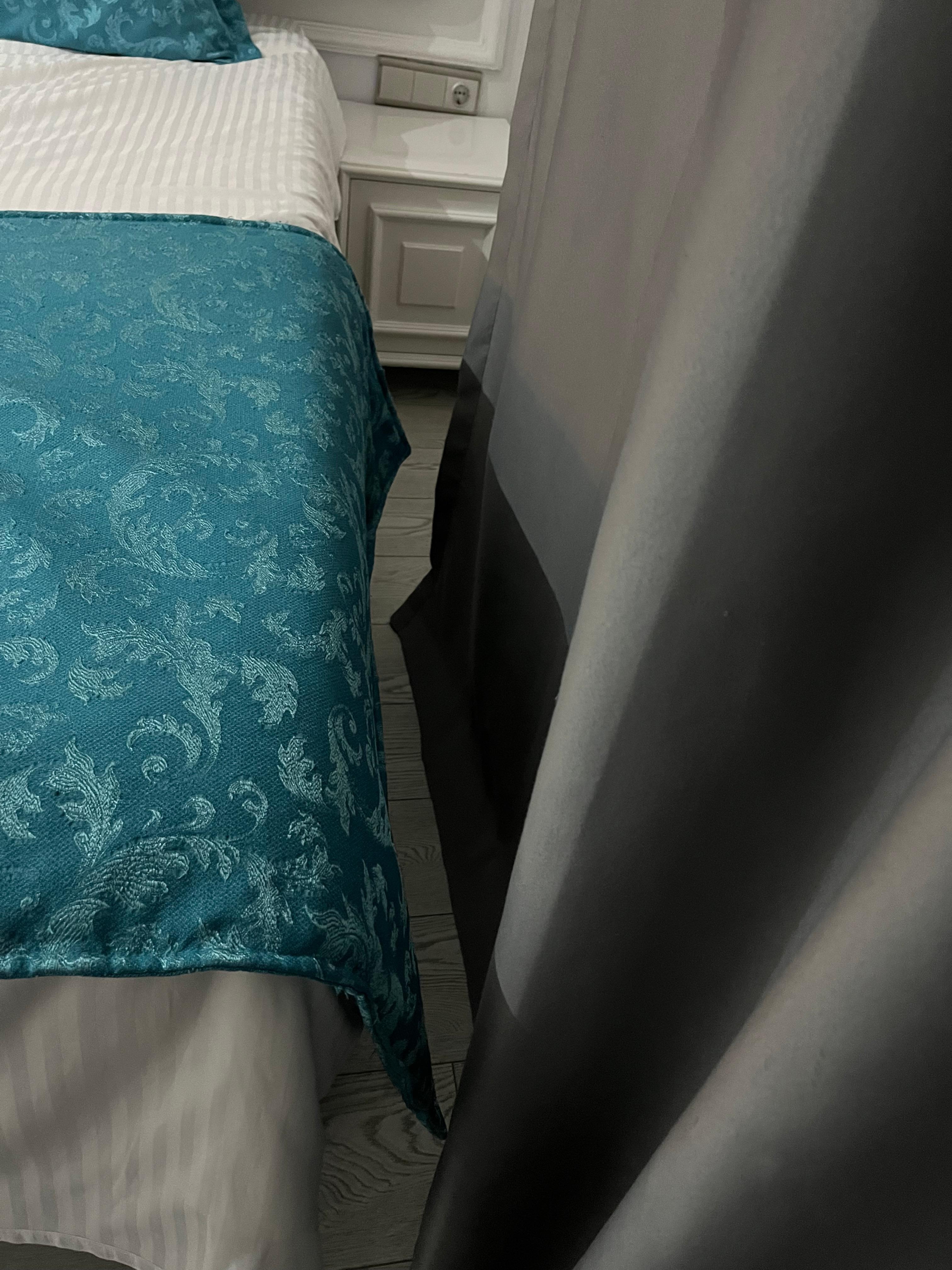 Between a bed and the wall.