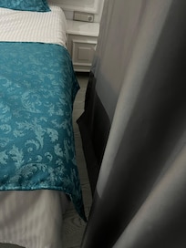 Between a bed and the wall.