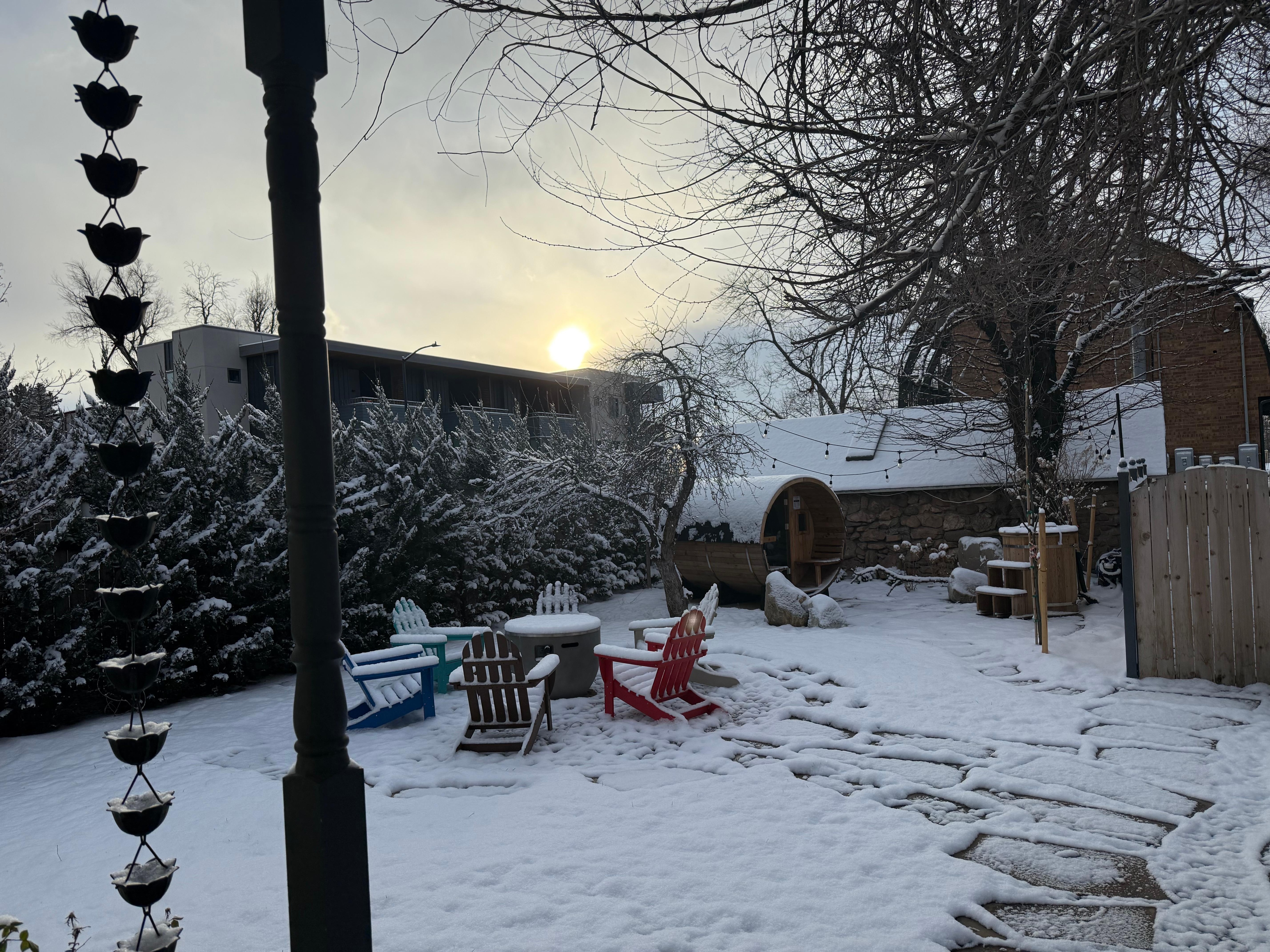 Backyard sauna, ice bath, and hot tub with a lovely snow cover. 