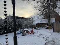 Backyard sauna, ice bath, and hot tub with a lovely snow cover.