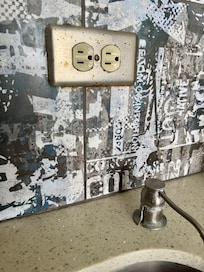 Old dirty kitchen with broken soap dispenser.