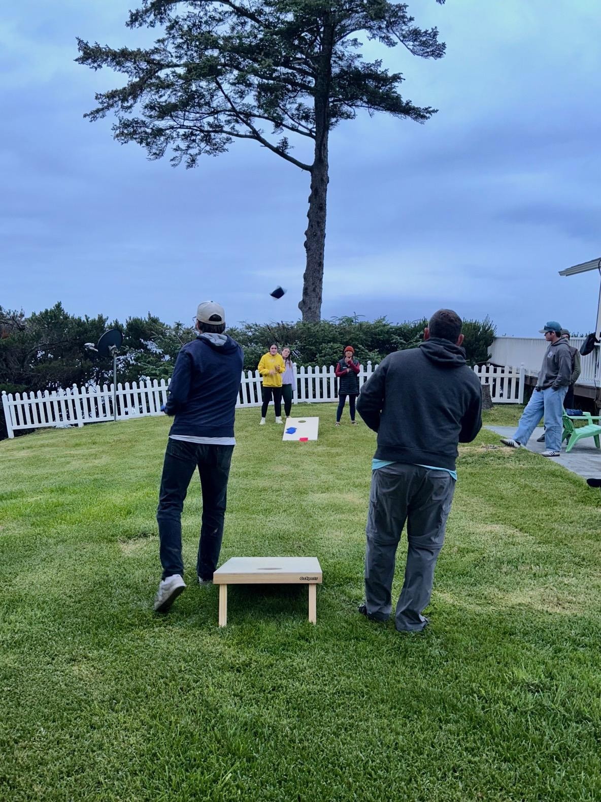 Family cornhole fun on the spacious side yard of house!