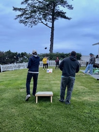 Family cornhole fun on the spacious side yard of house!