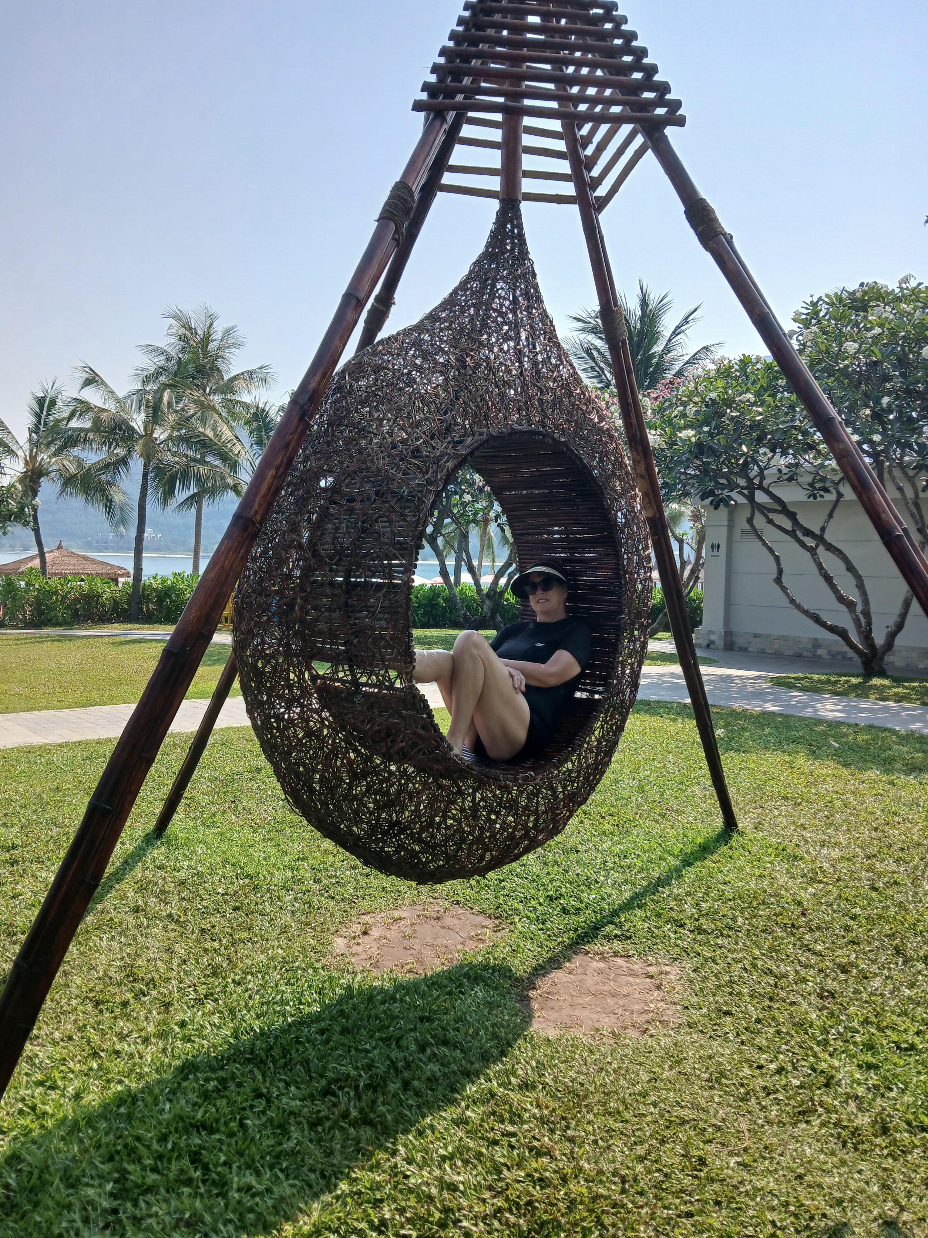 Relaxing in a hanging chair poolside