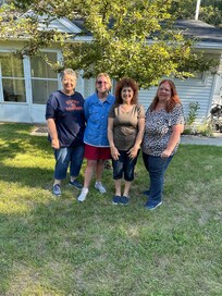 4 of the 5 in front of the house before checking out