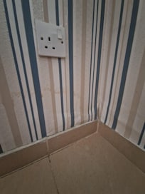Damp up wall near socket- wallpaper loose
