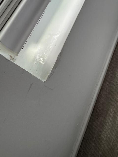 Water running into the bedroom window, dripping onto the wet carpet.