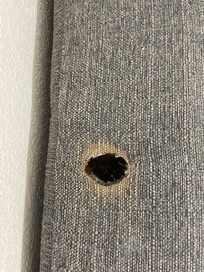 Trou de cigarette dans le canapé lit