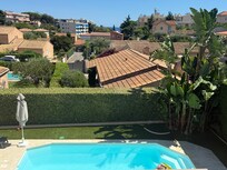 Views from the outdoor seating and dining area across the pool and over to the sea