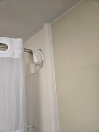 Leftover dirty washcloth hanging from shower rod.