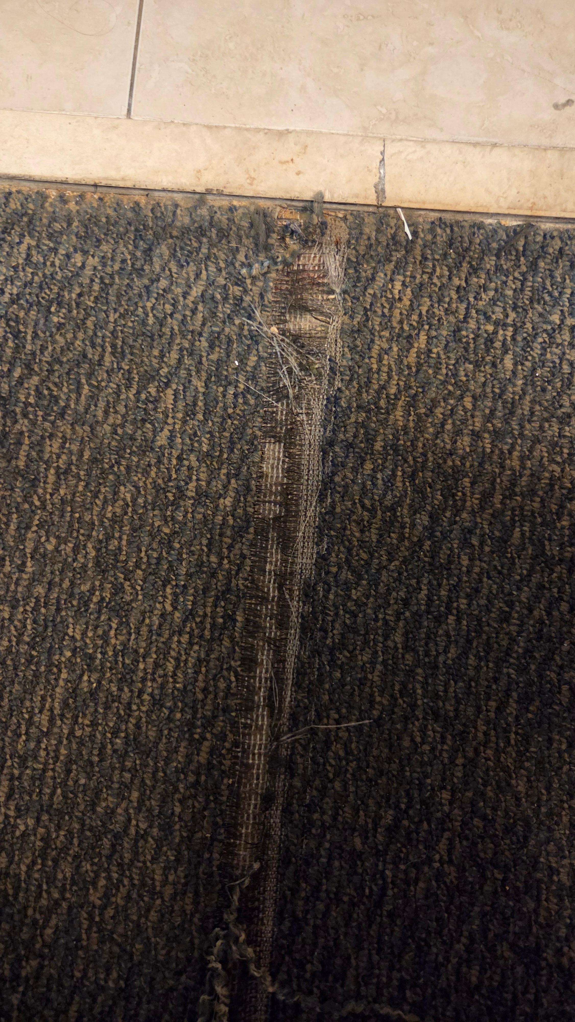 Unclean floor. Ripped carpet