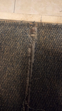 Unclean floor. Ripped carpet