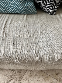 couch that appears to have been used as scratching post by a cat