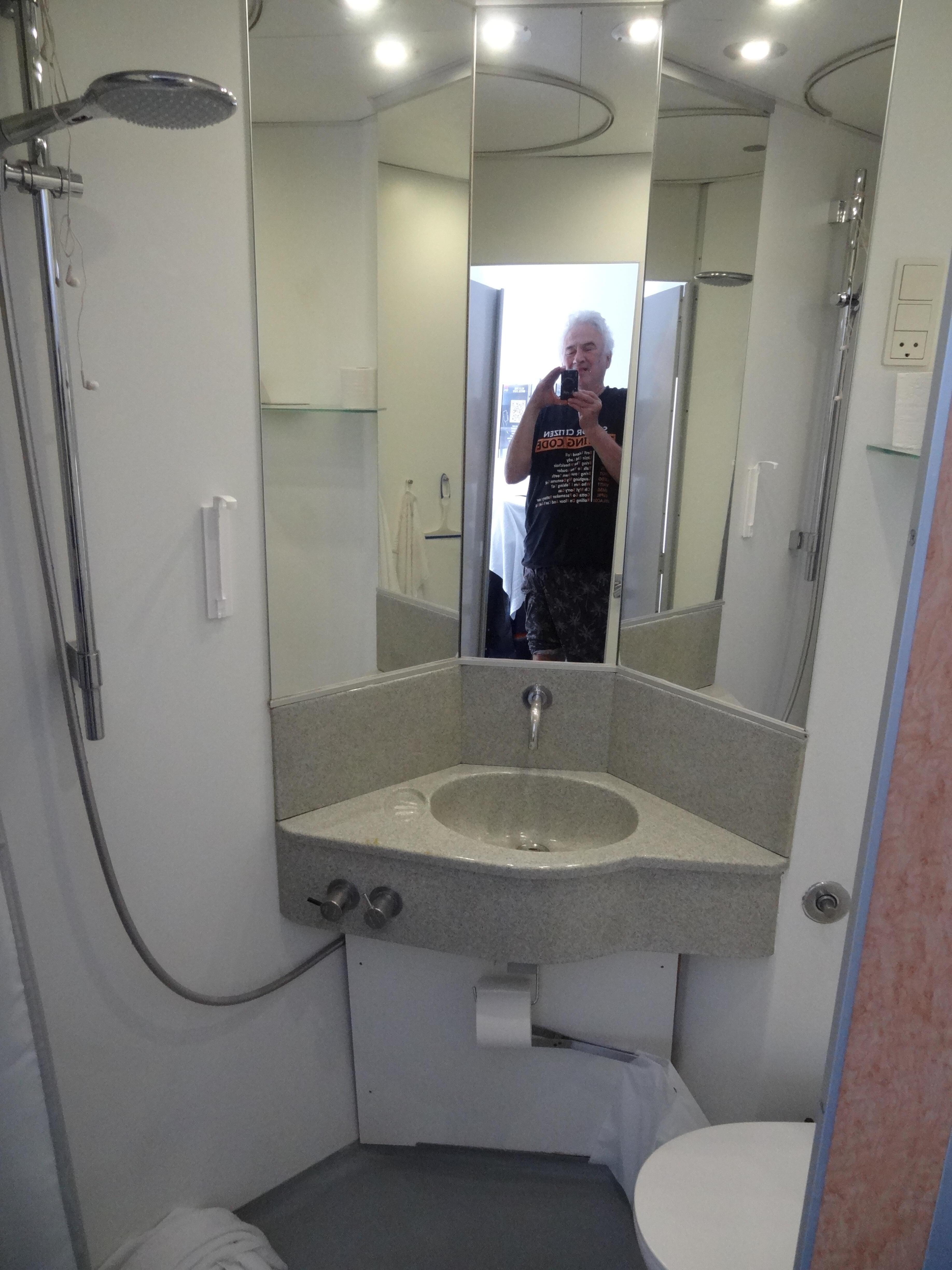 Small, workable bathroom but shower head needed work (scary picture on wall!)