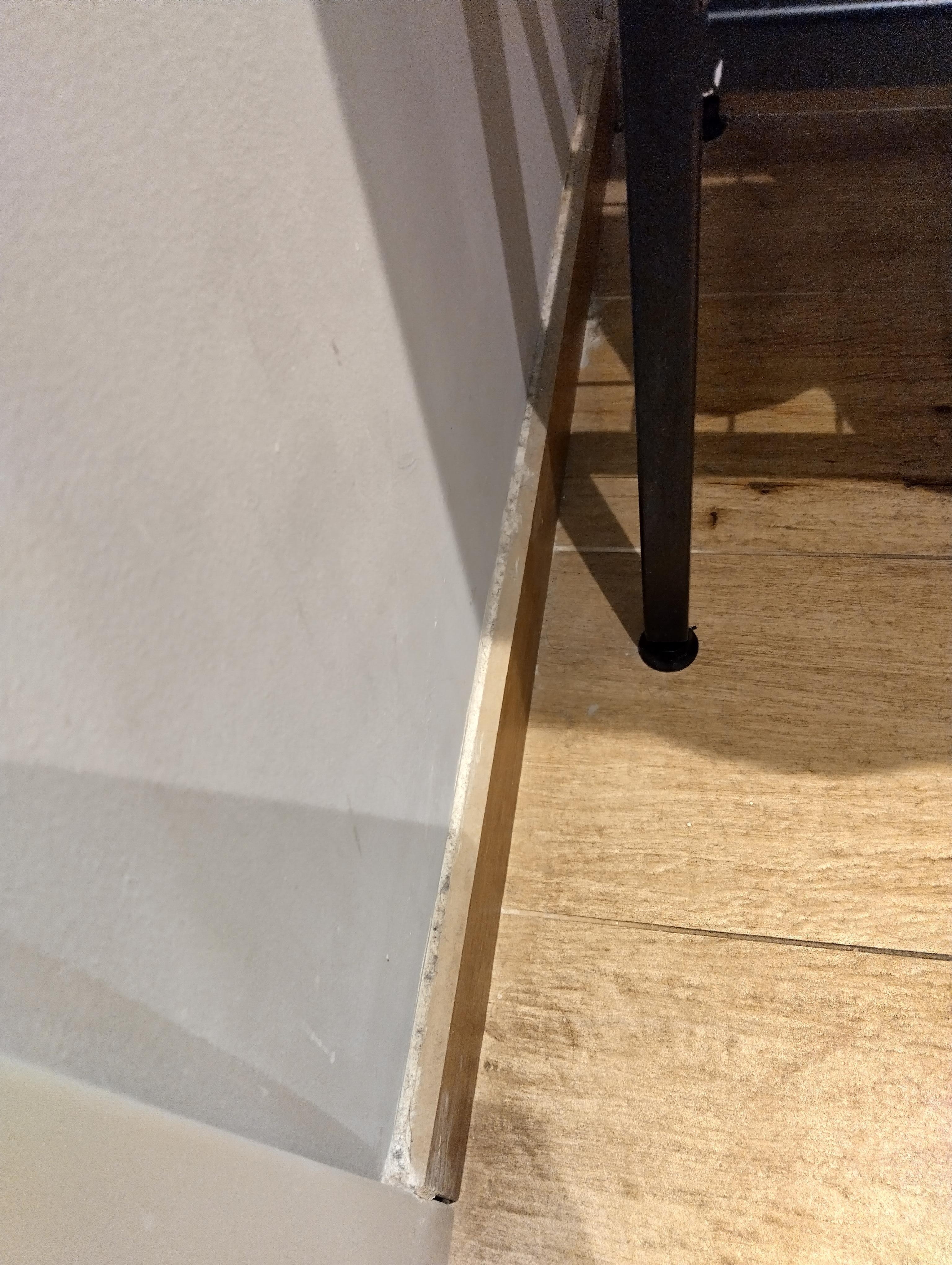 Top of skirting board beneath sink covered in dust.