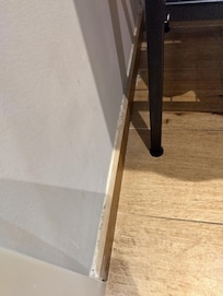 Top of skirting board beneath sink covered in dust.