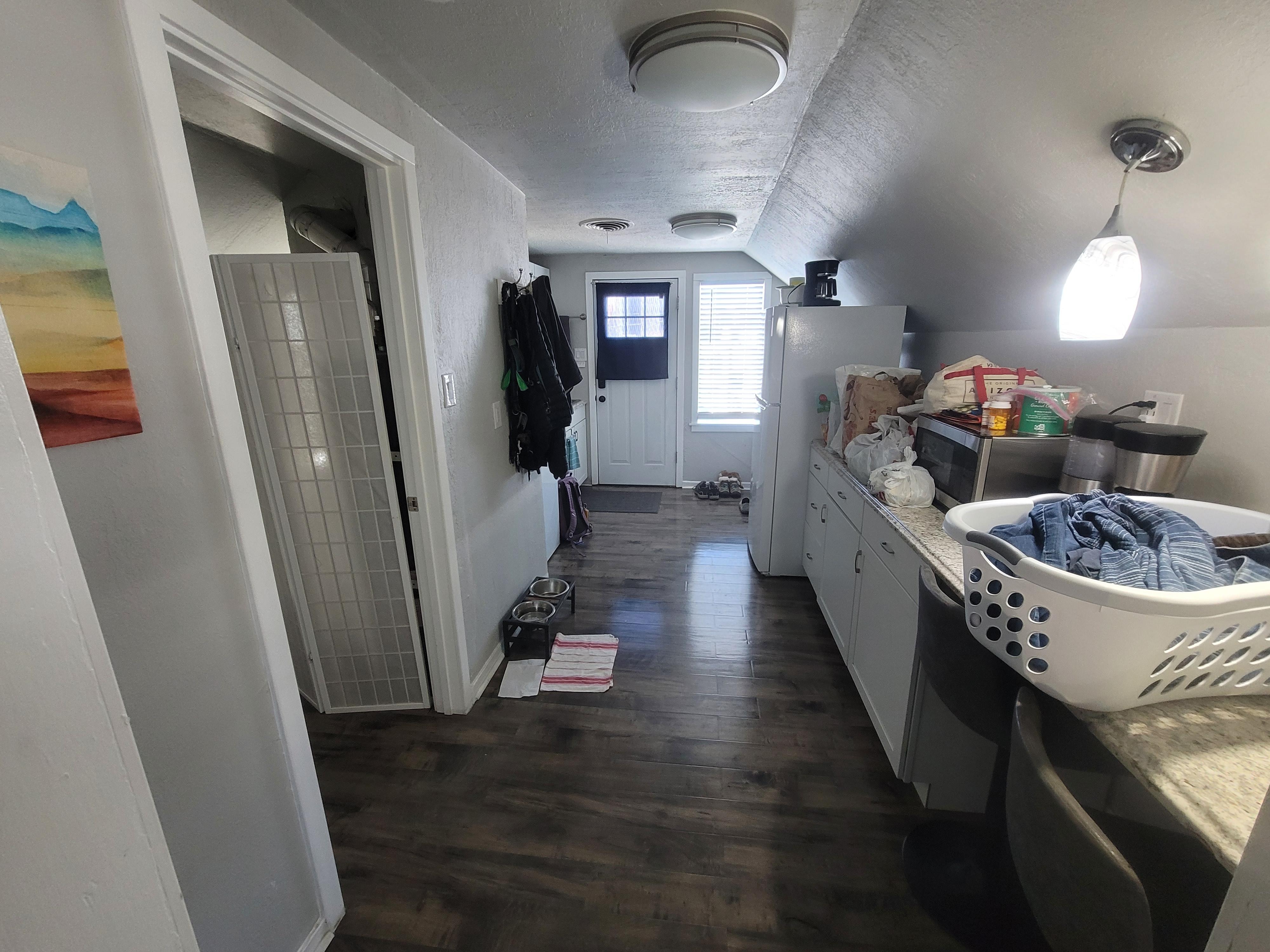 View looking from bedroom through TV room to kitchen & entrance.