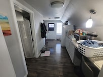 View looking from bedroom through TV room to kitchen & entrance.