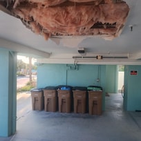 garbage in stairwell and debris falling out of the damaged ceiling above parking