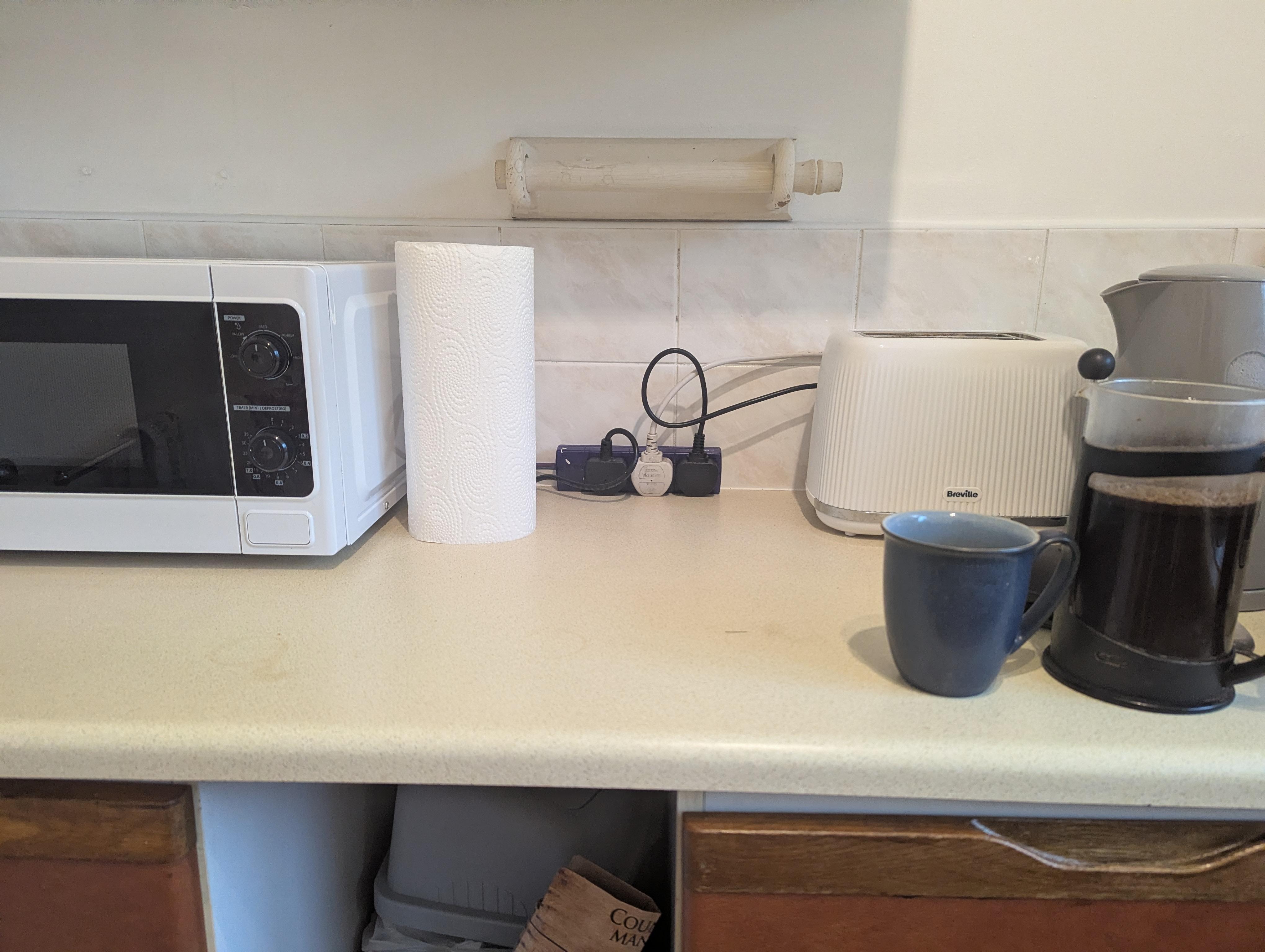 Fire Risk -Use of 3 gang extension lead, sitting on kitchen worktop, overloaded with multiple appliances microwave/toaster/kettle is dangerous