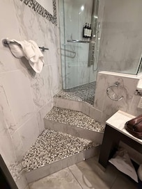 Decorative tile on an angled staircase leading up to the shower. It's an absolute deathtrap. I'm lucky my injury fell short of that -- not everybody's will. Does Quebec not have building codes?