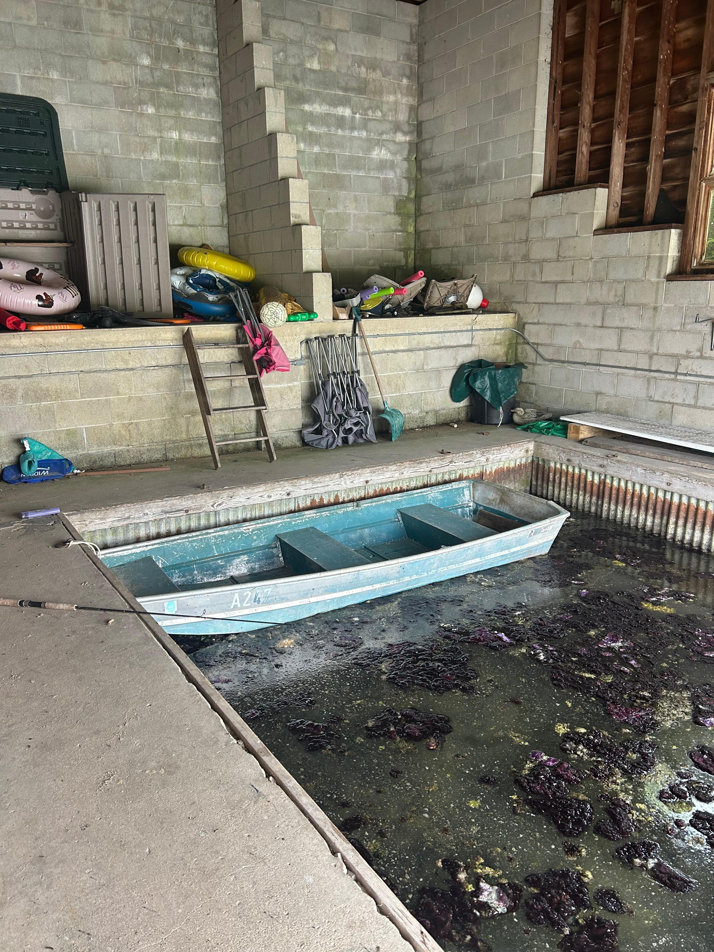 Boat house with gross algae and worn out equipment 