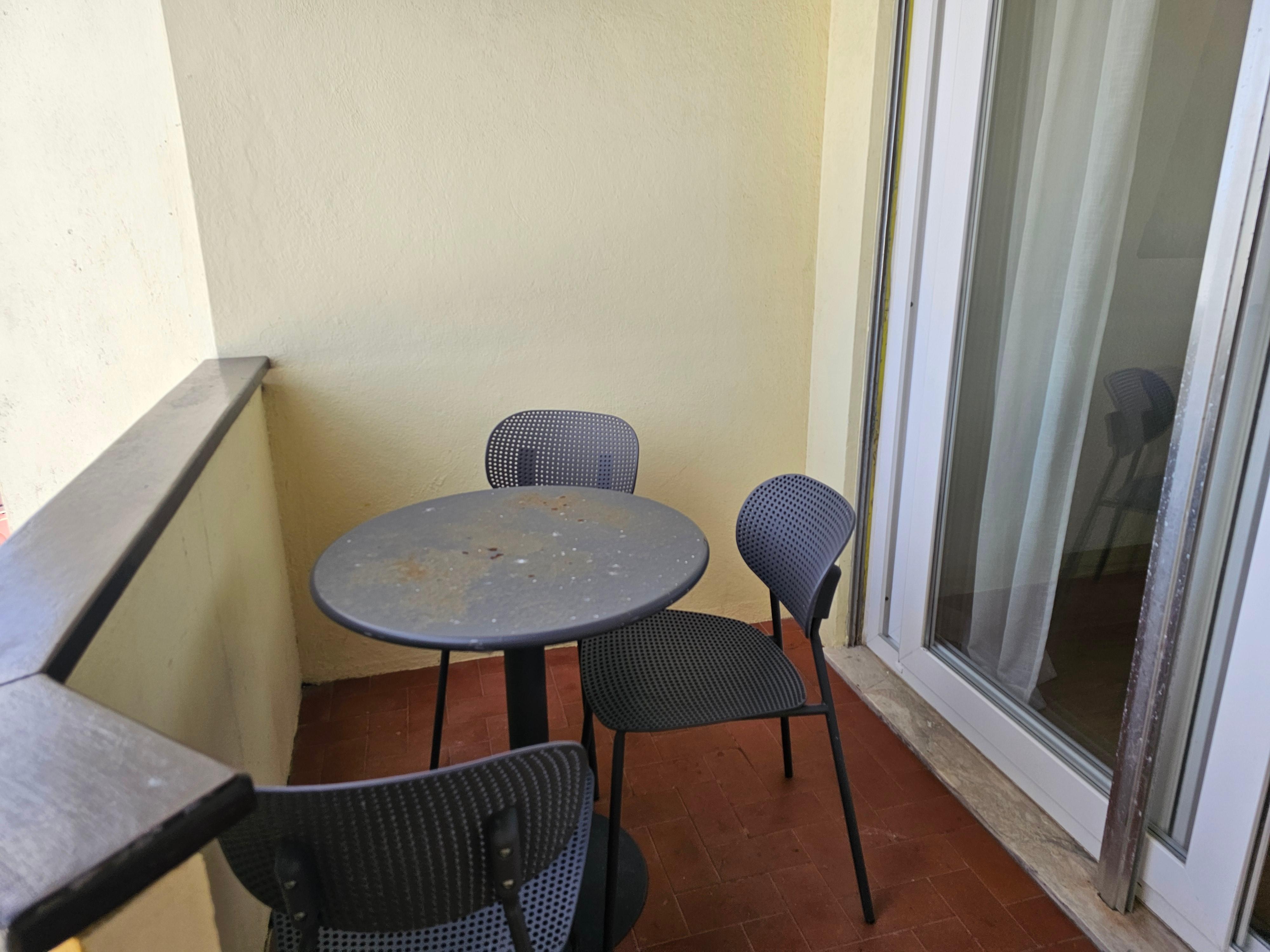 Balcony and rusted metal balcony table and chairs