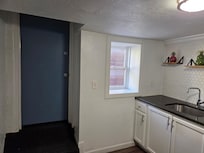 Exterior door to side yard/driveway with uncovered window.