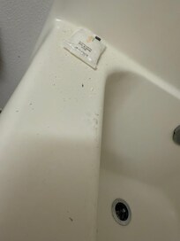 Hair and drywall debris on the tub.