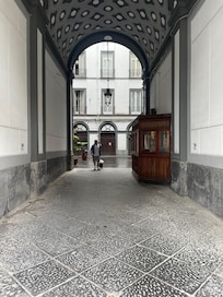 The entrance from the street. This is concealed by a traditional huge wooden door which is opened at certain points during the day by the friendly caretaker for the building. The entrance to Antica Dimora Pessina is on the left of the courtyard.