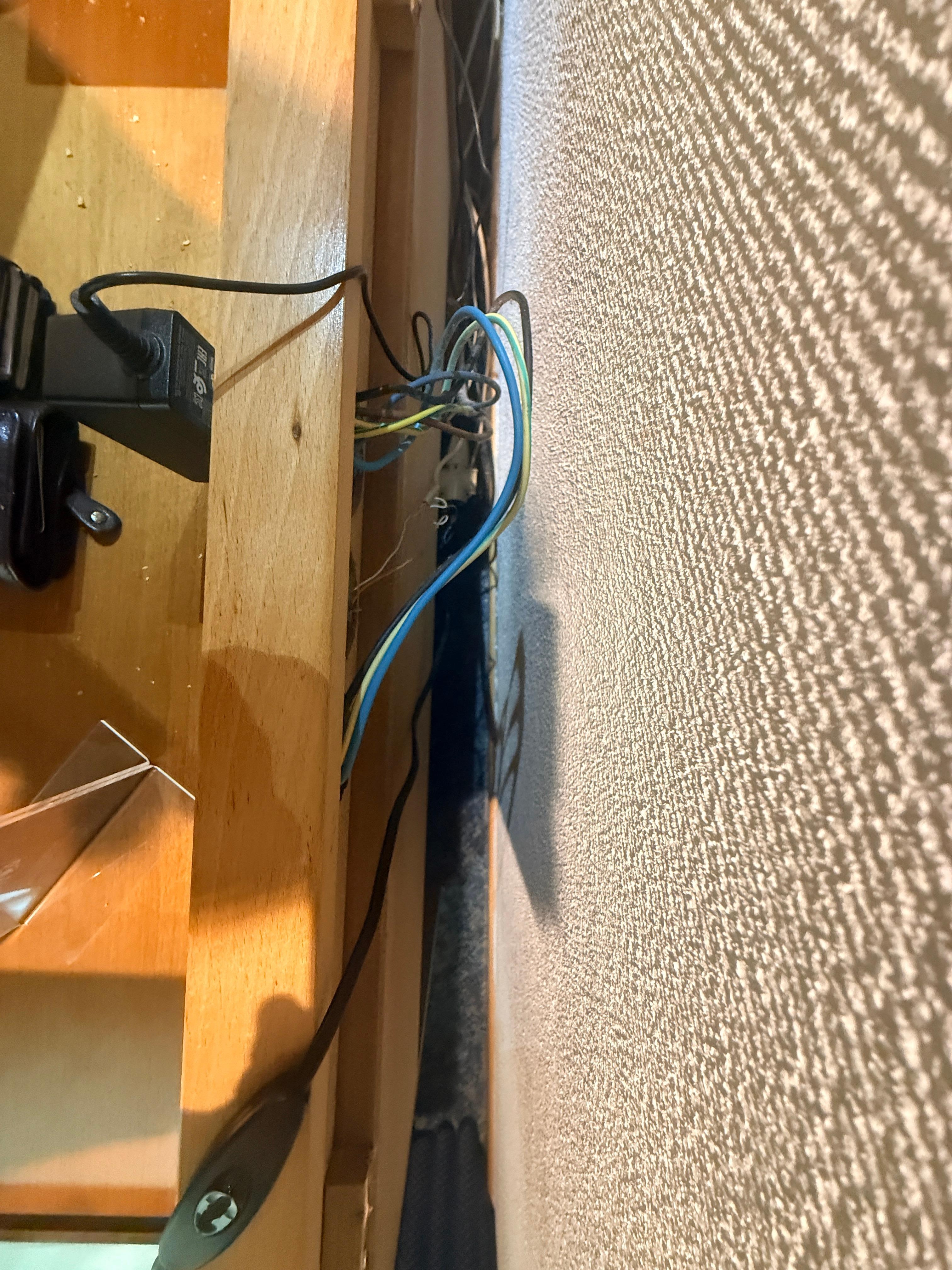 Plug sockets occupied by minibar and TV with exposed rear wiring. As a qualified electrician, I can’t stress enough how dangerous this is and should be rectified accordingly.