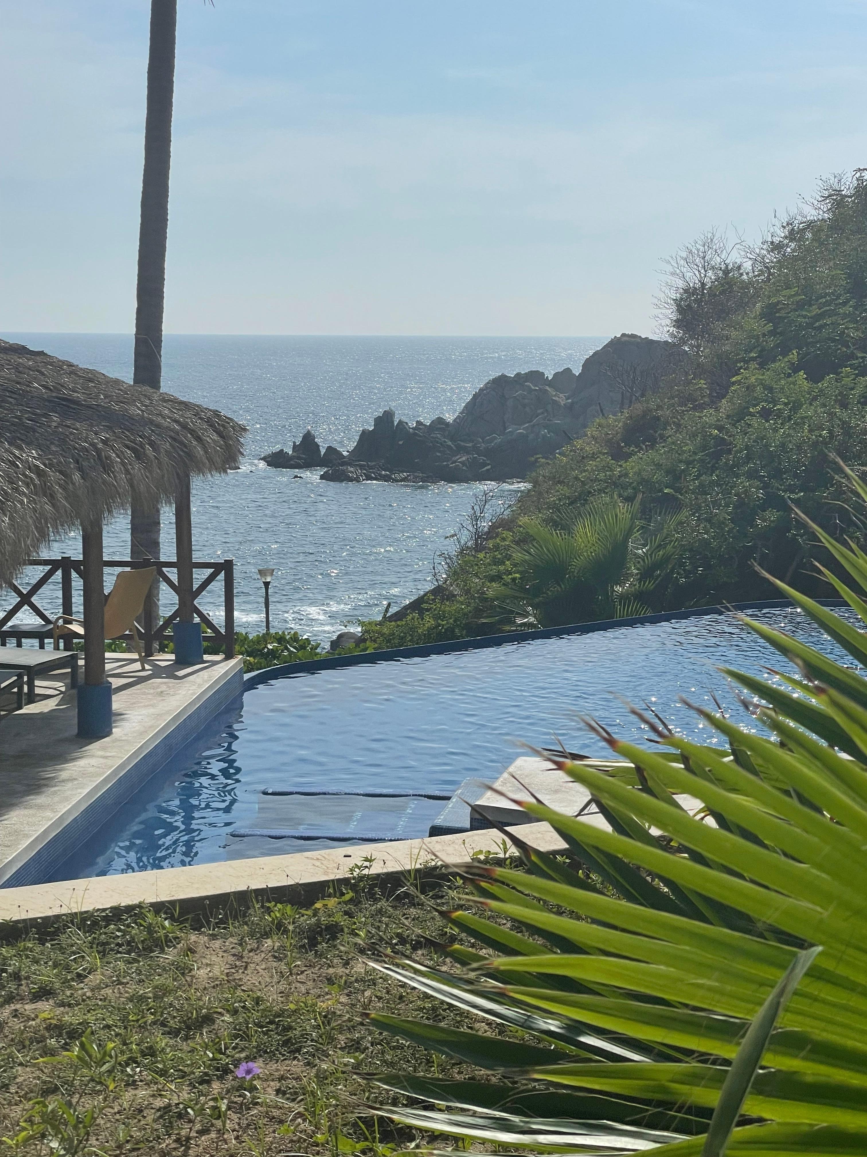 Infinity pool right over ghe rocky beach