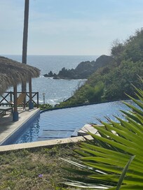 Infinity pool right over ghe rocky beach