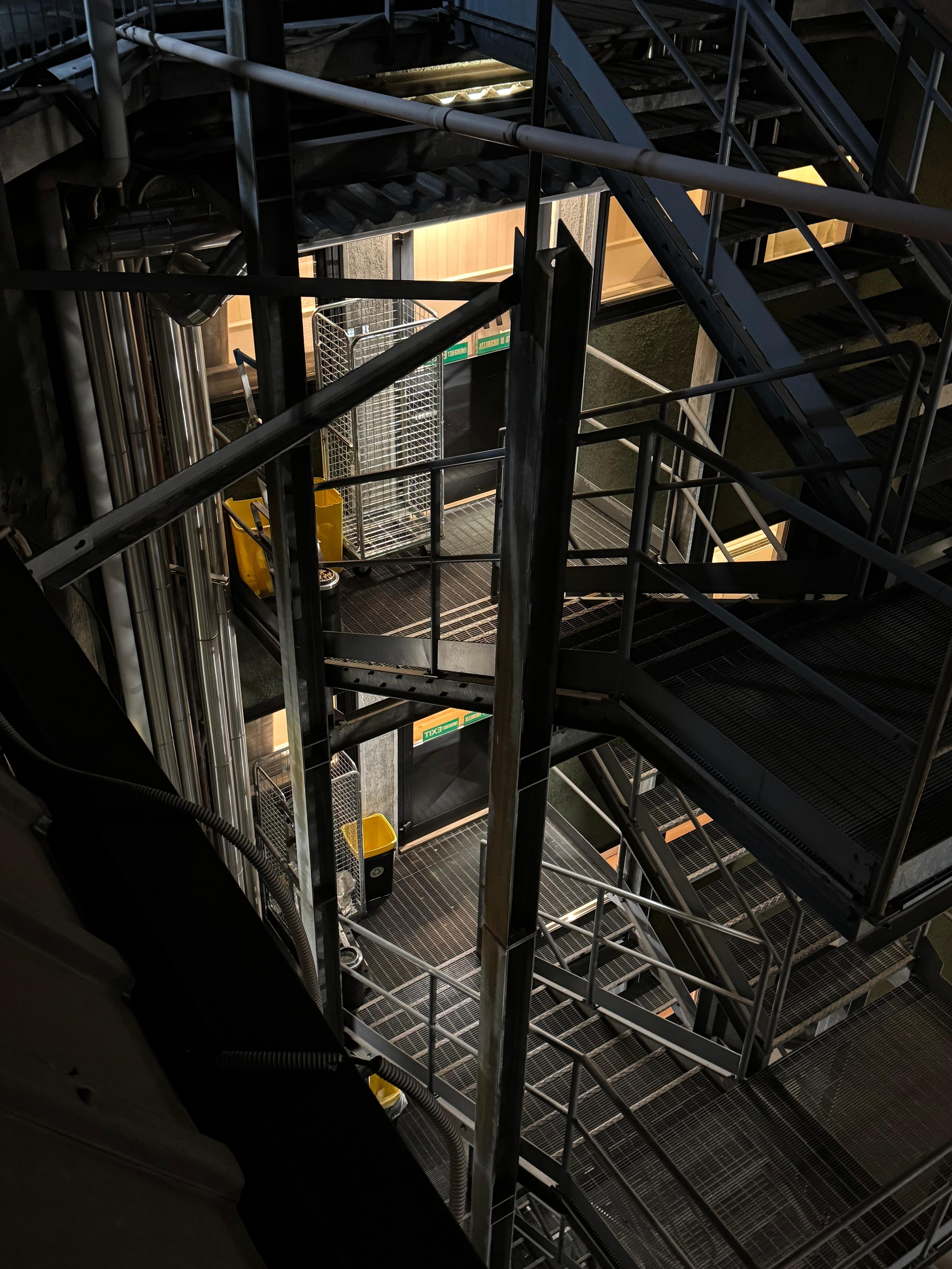 Laundry carts plus bins on fire escape of two upper floors.