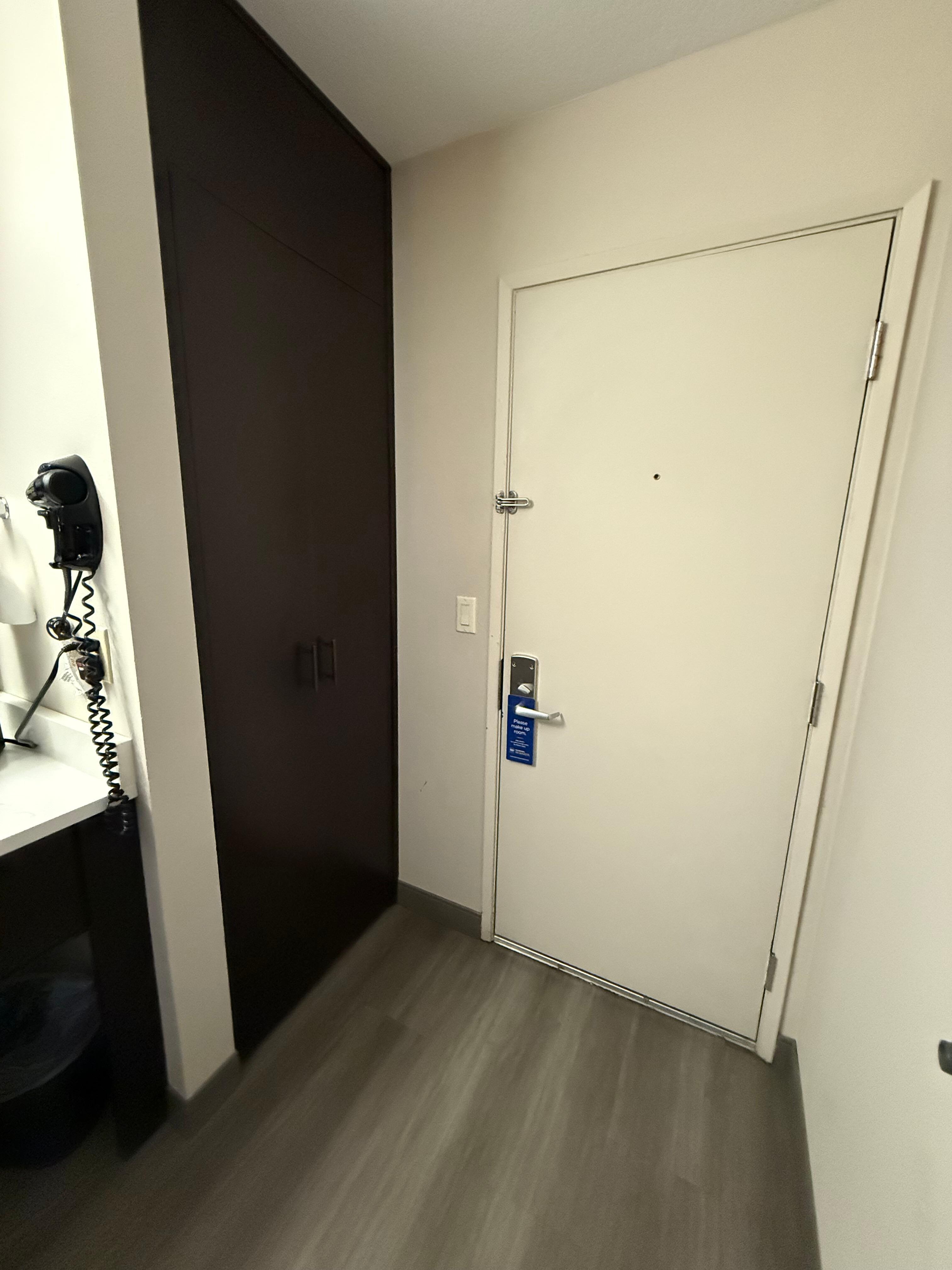 Secure door and small closet with ironing board and iron and luggage holder