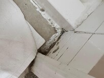 Filthy caulking between shower base and wall.