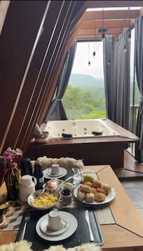 Mesa do café da manhã, banheira. Que paisagem!