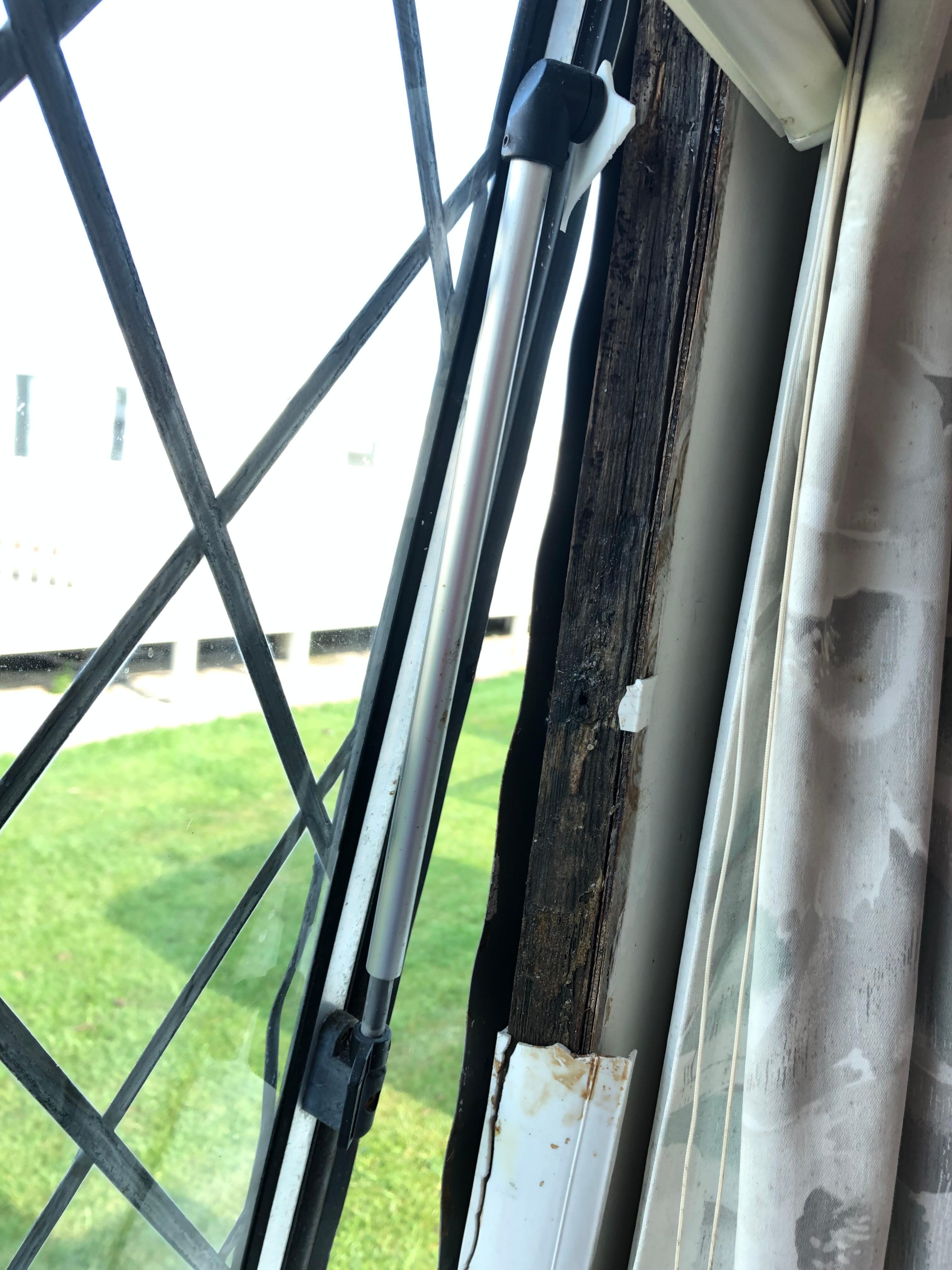 Exposed rotten timbers behind blind