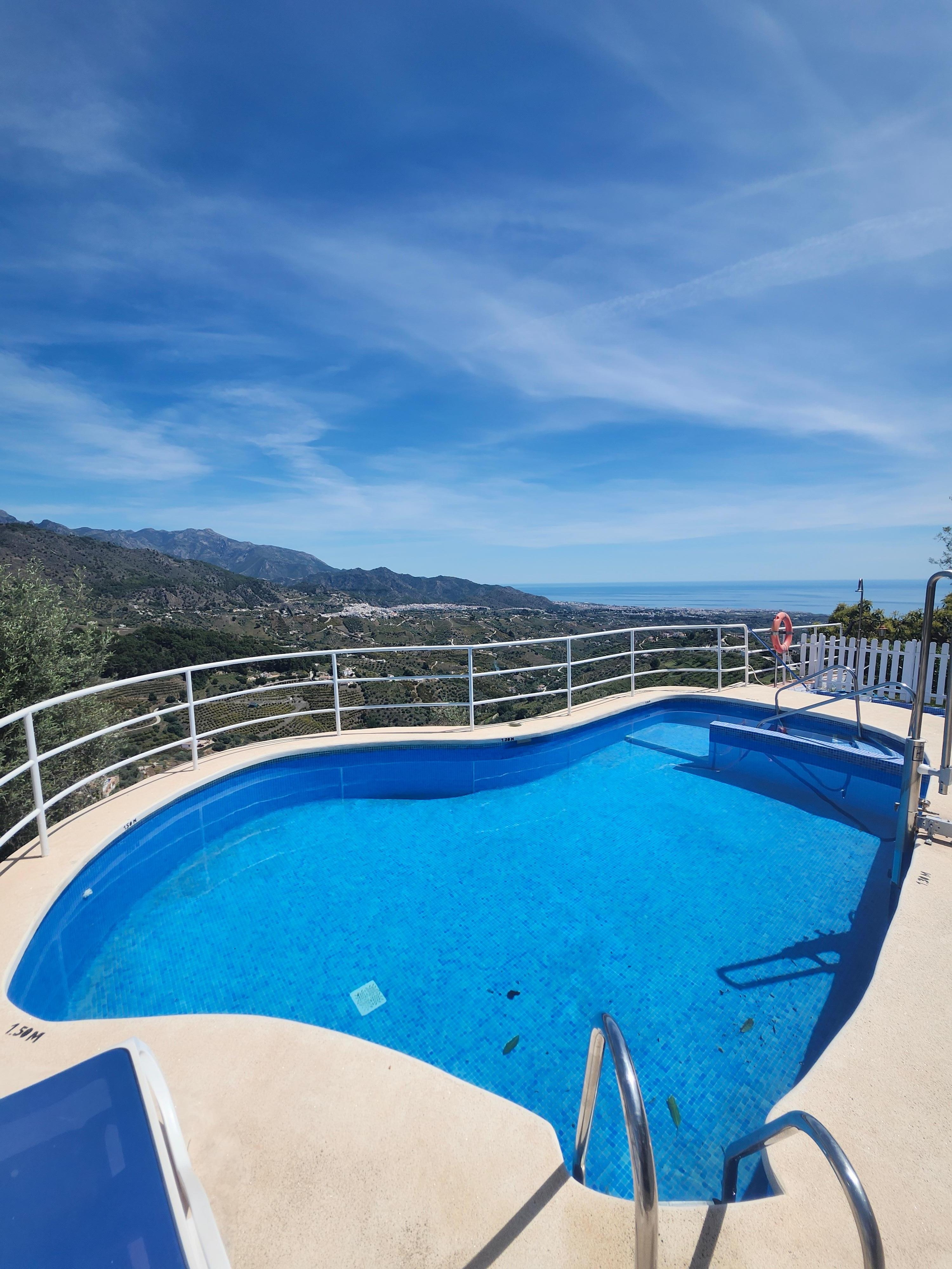 pool with a top tier view and a buncha tanning chairs