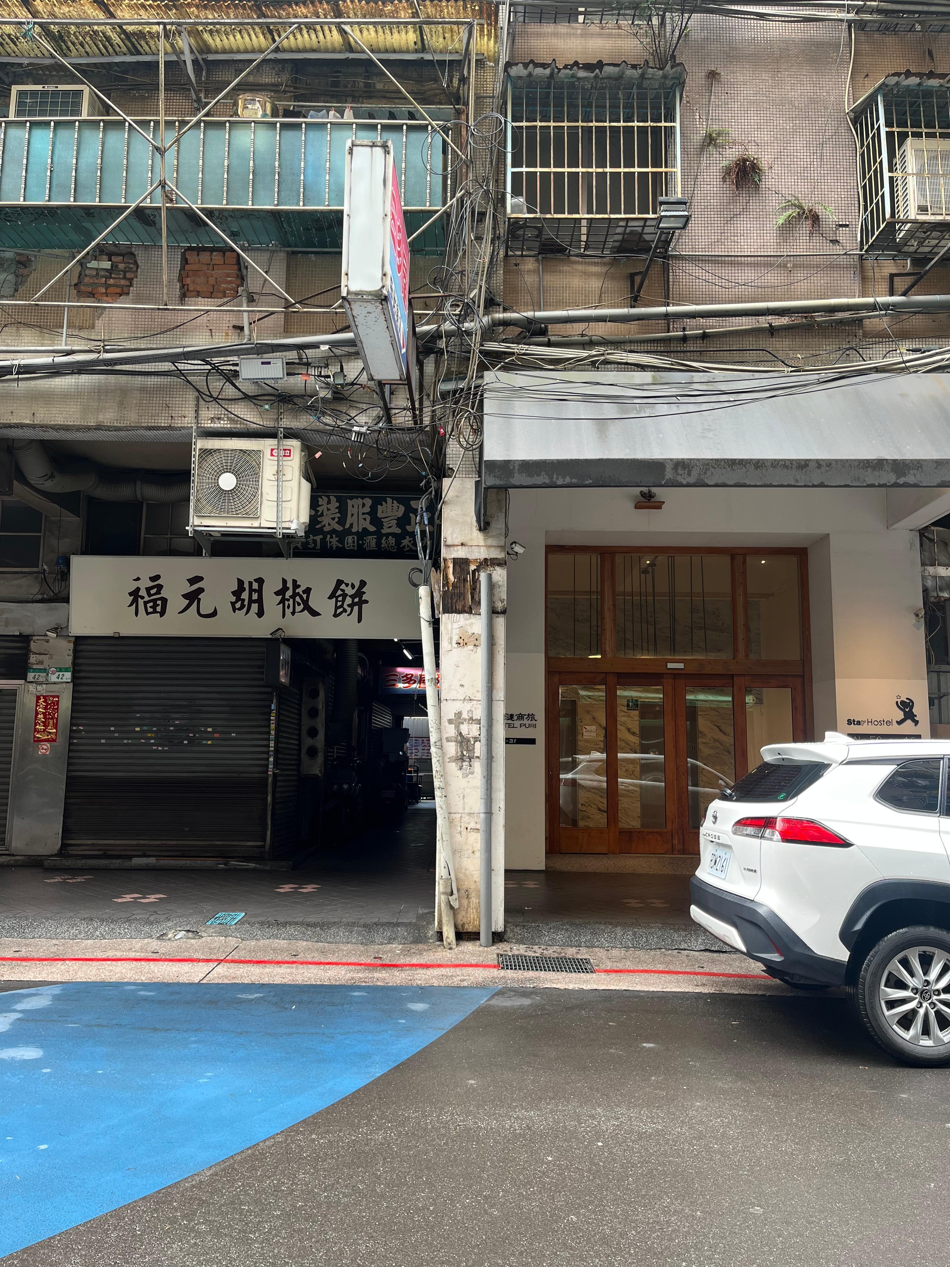 ホ テルの入口。隣は人気の胡椒餅屋さん。なかなか買えないので次の焼き上がりを予約してね。